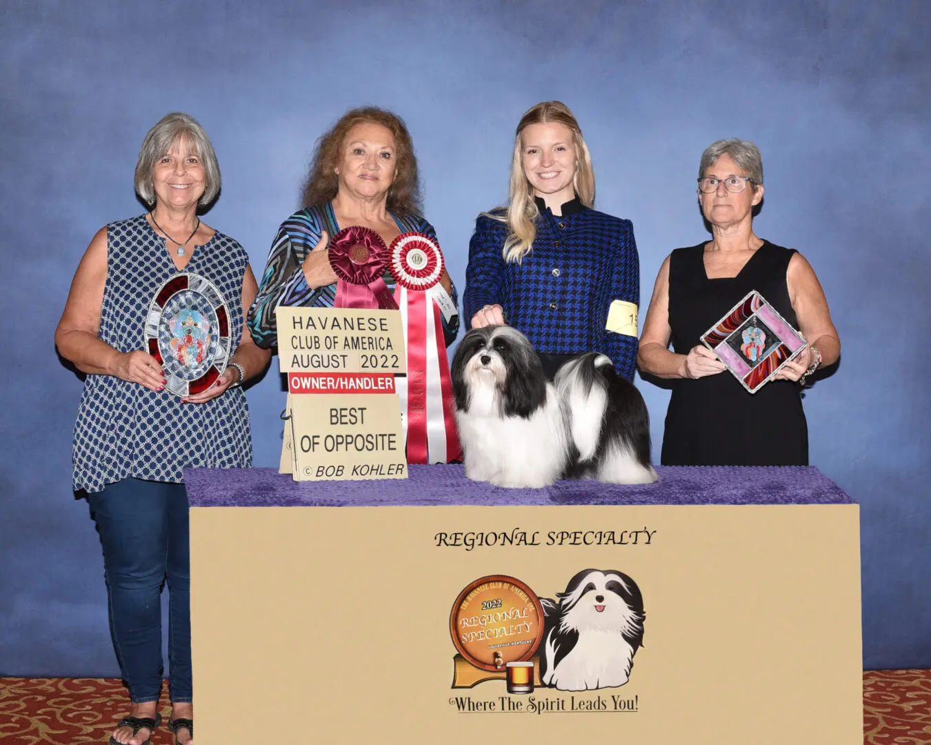 A group of women, proud havanese breeder in Chicago, Illinois, posing with their dogs and trophies