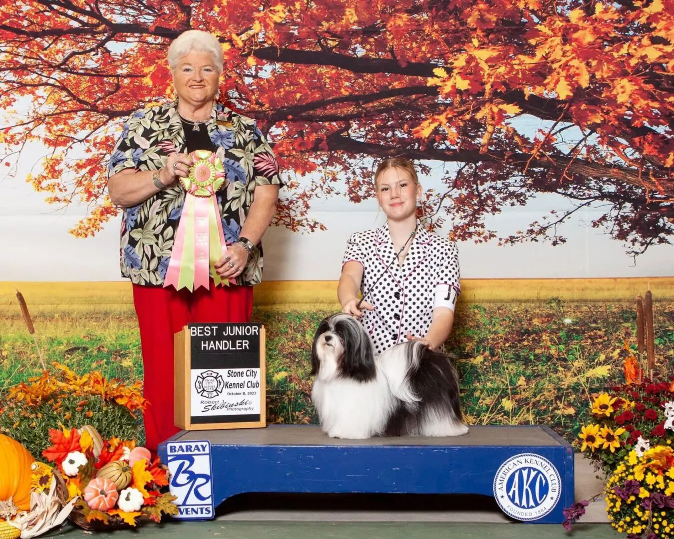 A woman and a Havanese dog posing for a picture.